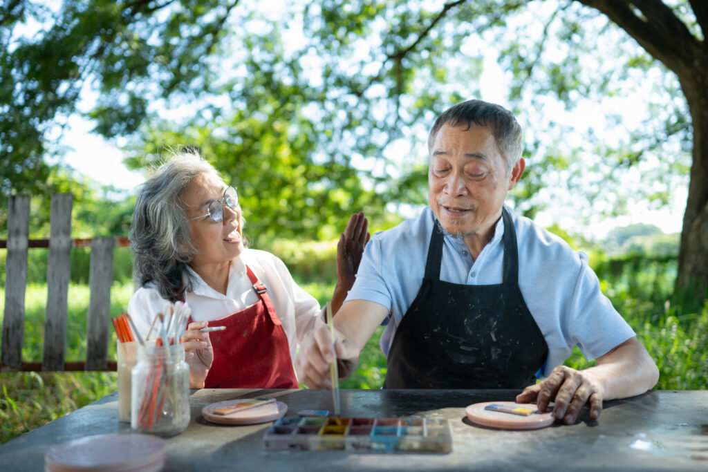 arteterapia para iniciantes - dois idos sentados em uma mesa pintando porcelanas