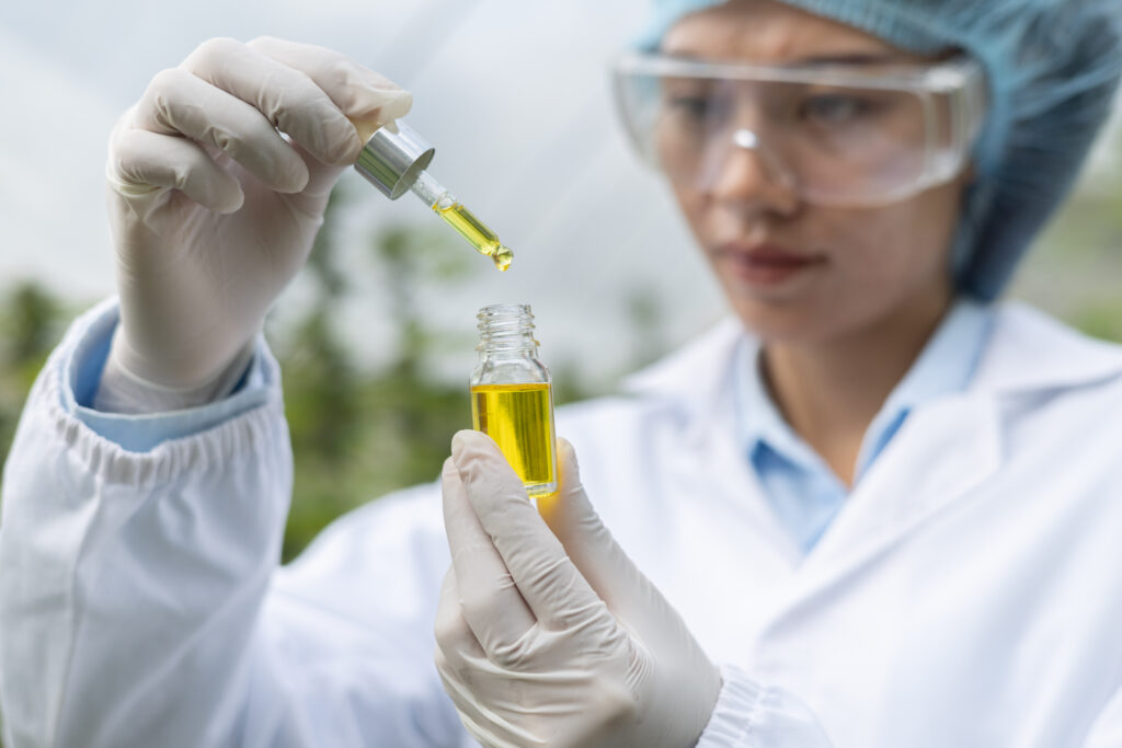 Como produzir oleos essenciais - mulher em laboratorio verificando um frasco de oleo essencial