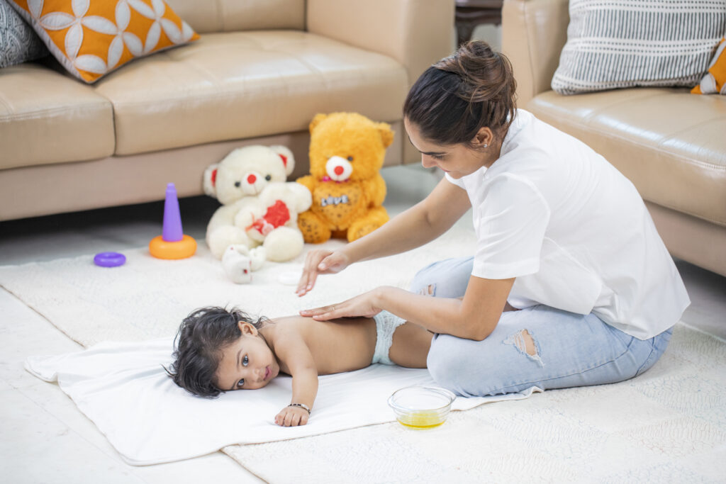 mulher aplicando massagem shantala em bebê