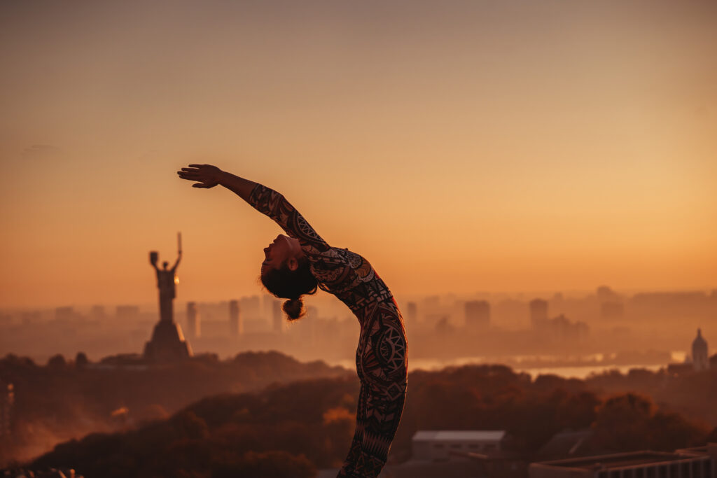 mulher praticando yoga ao por do sol